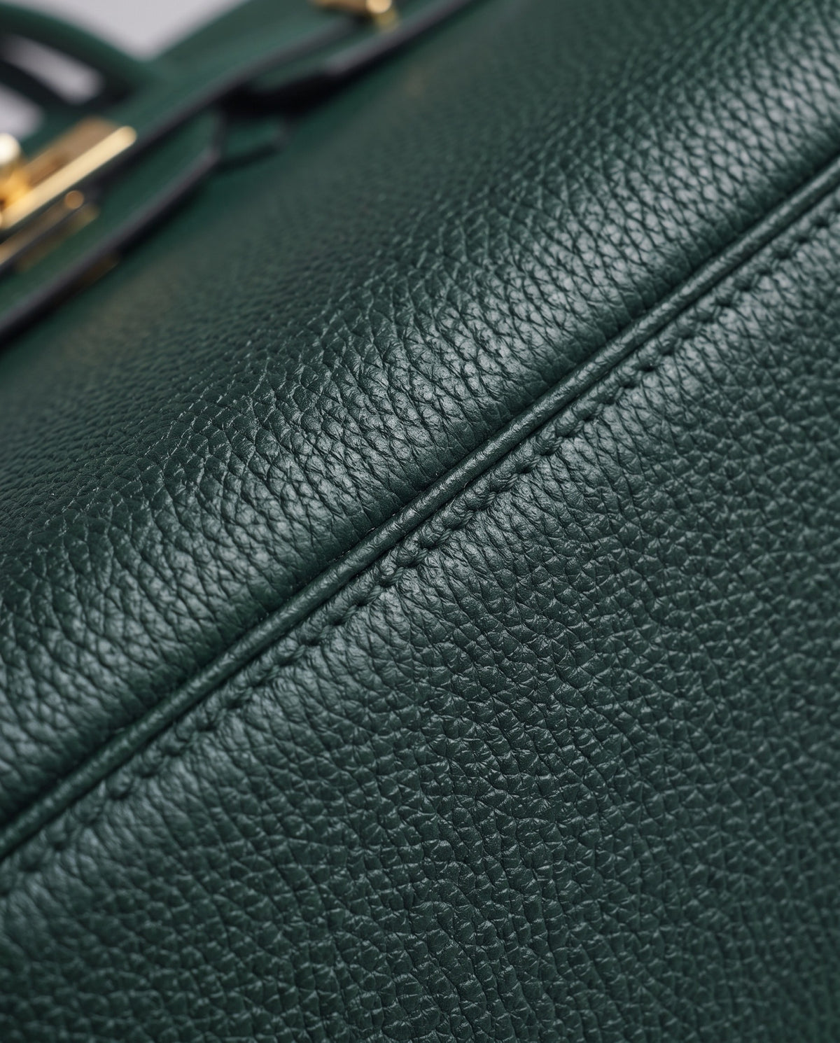 Lock Small leather top-handle bag in Emerald – close-up of the pebbled leather and stitching