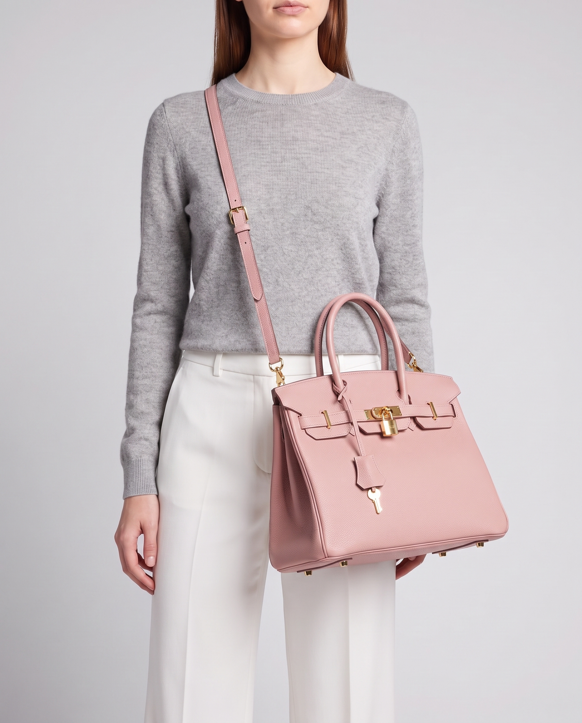 Lock Small leather top-handle bag in Pink – model wearing it crossbody on the detachable shoulder strap