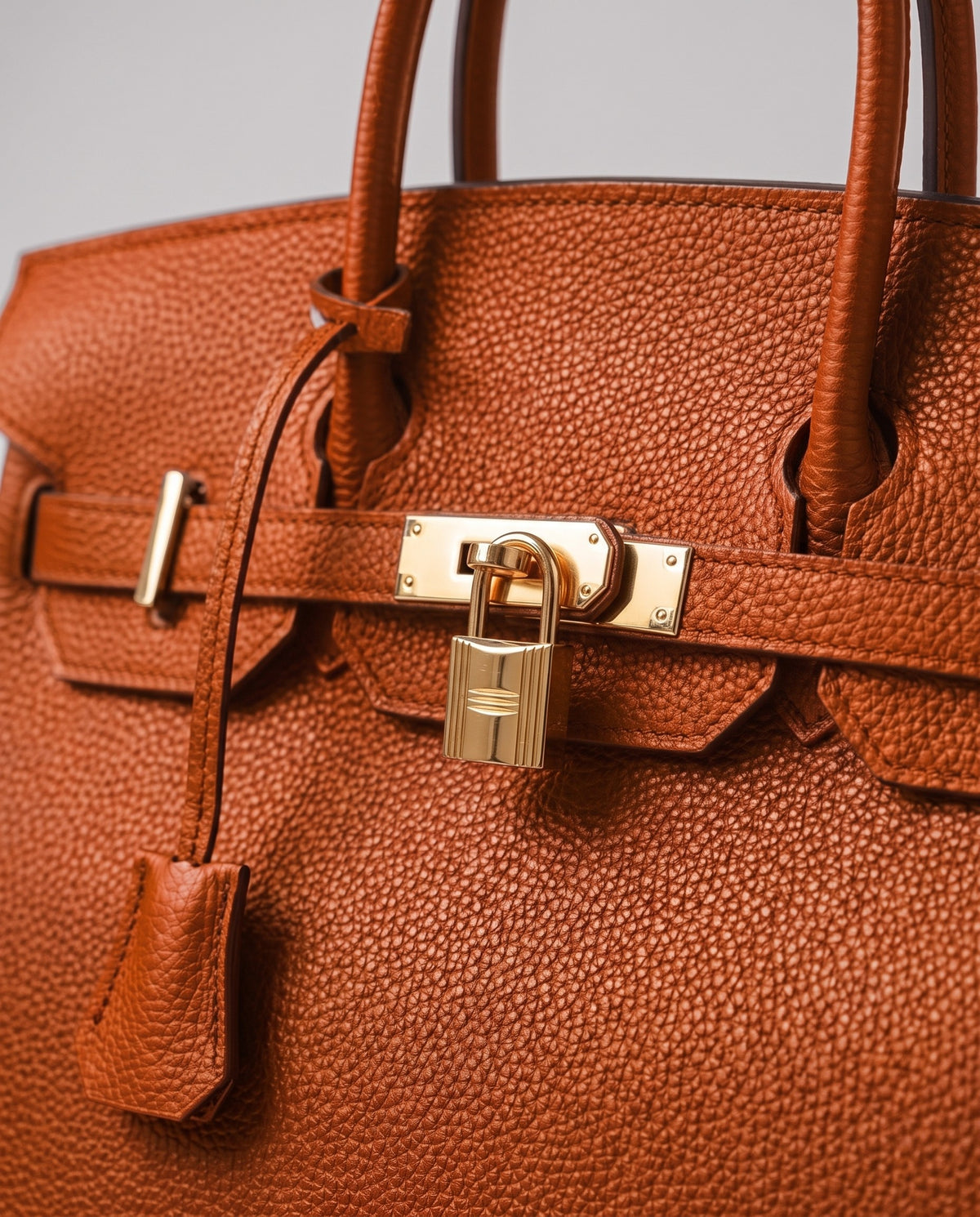 Lock Small leather top-handle bag in Terracotta – close-up of the gold turn-lock and padlock
