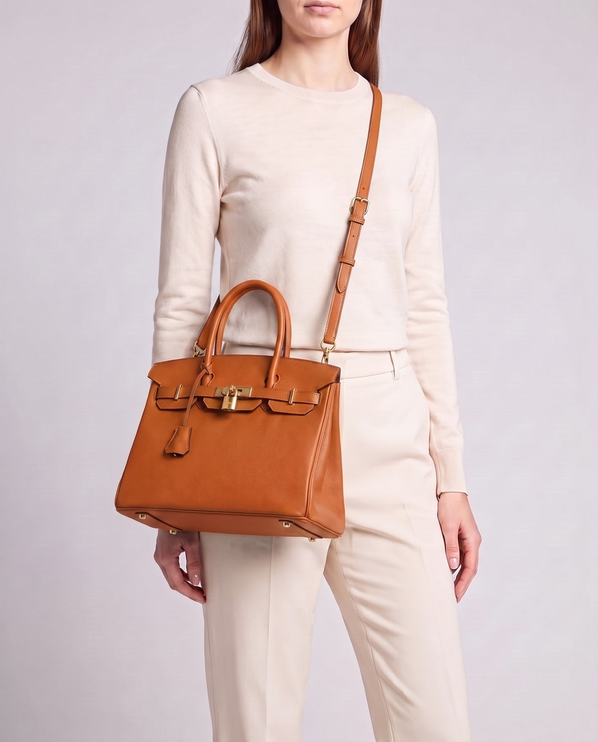 Lock Small leather top-handle bag in Terracotta – model wearing it crossbody on the detachable shoulder strap