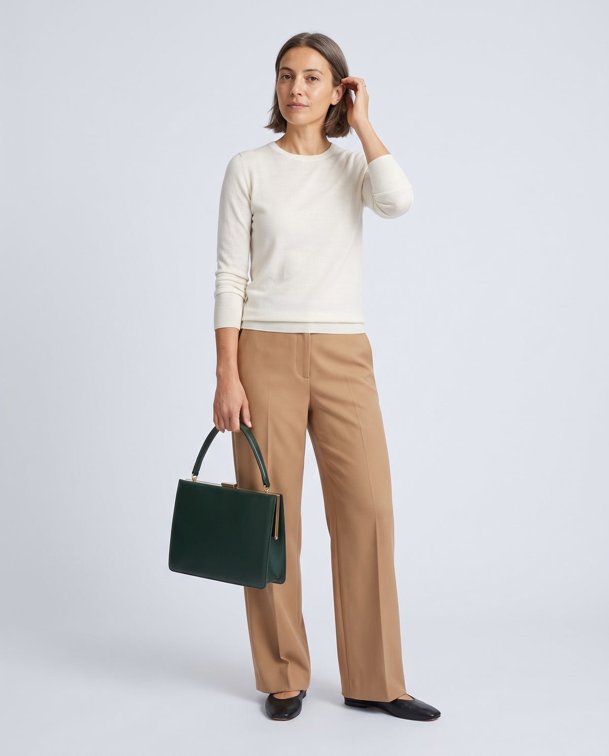 Model carrying the Marilyn top-handle bag in Green leather – full length