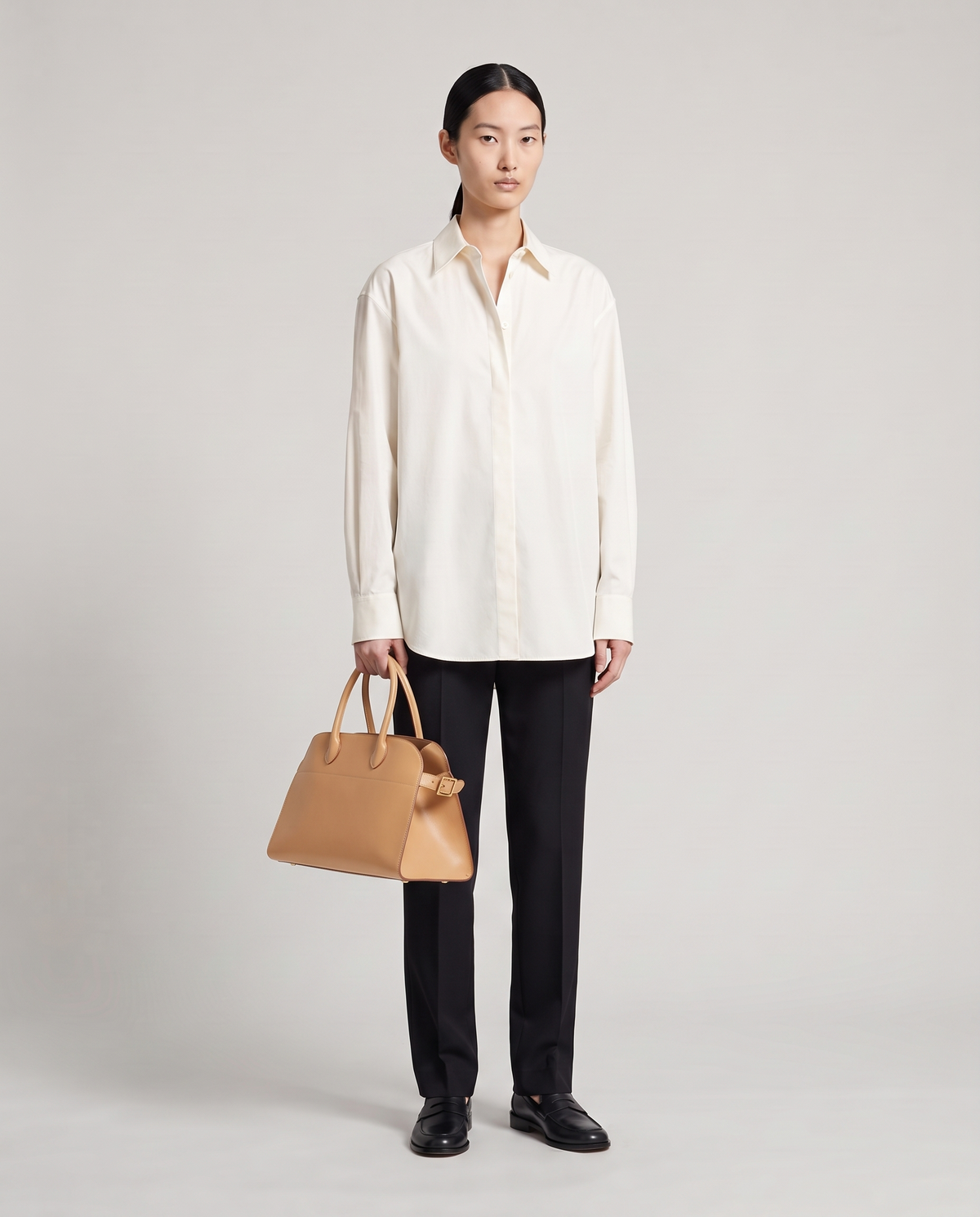 Milano Small top-handle bag in Tan – model holding it by the top handles, full length
