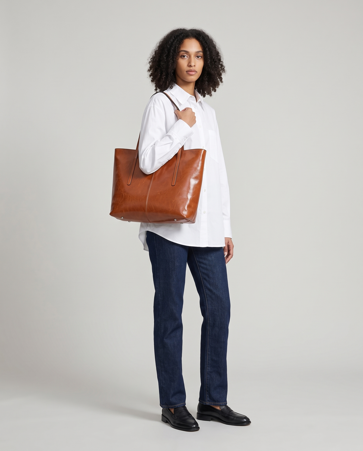 Model carrying the Molo leather tote in cognac on her shoulder, full length