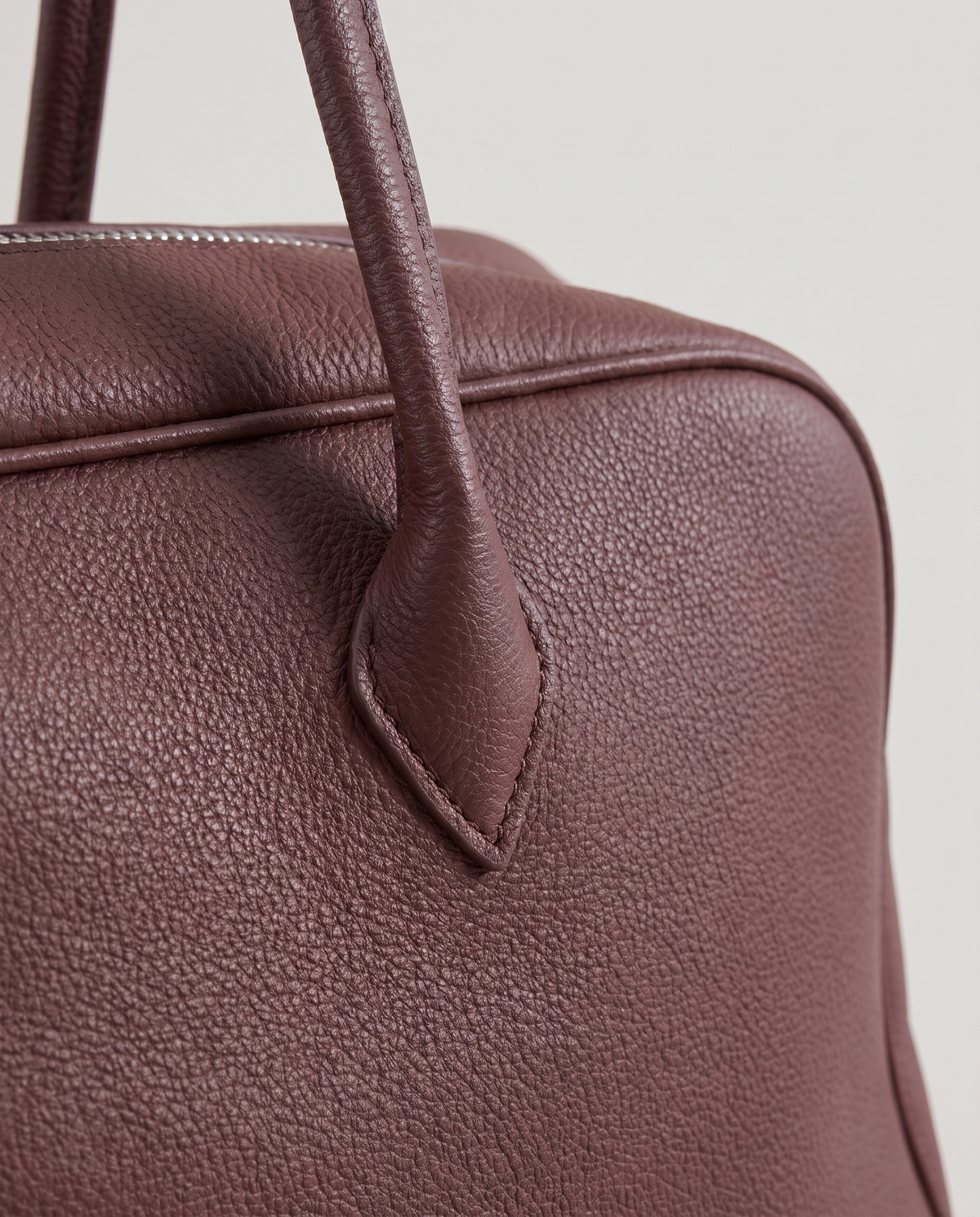 Ora Small leather shoulder bag in Chocolate – close-up of the strap tab and pebbled leather