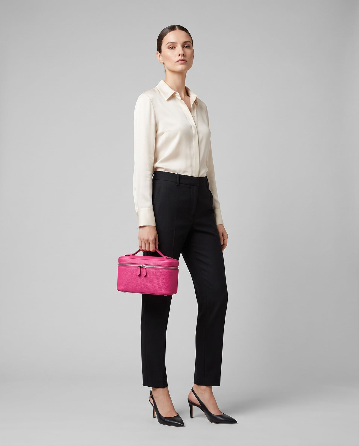 Model holding the Orvieto vanity case in Fuchsia – full-length view