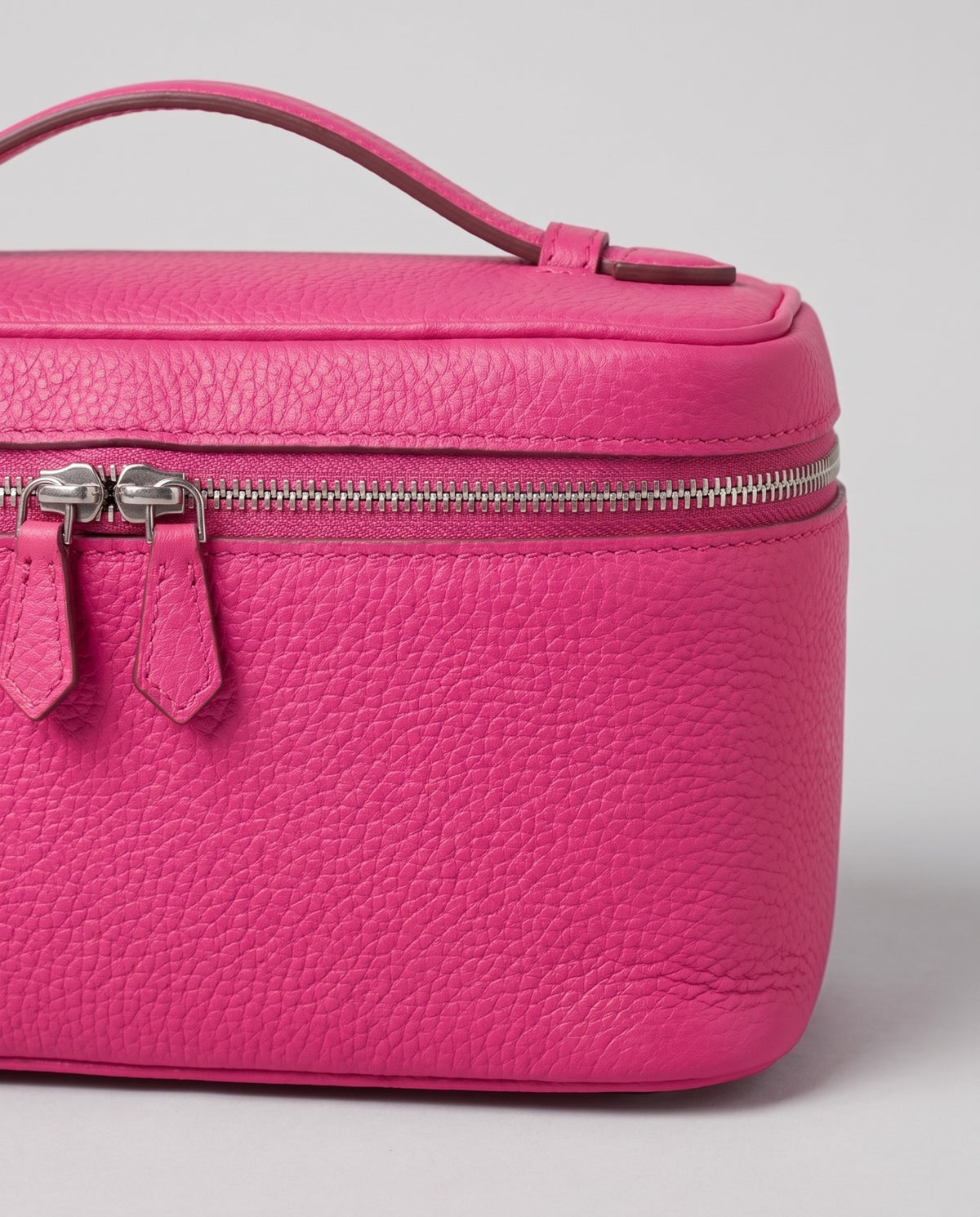 Close-up of the pebbled cowhide leather on the Orvieto vanity case in Fuchsia