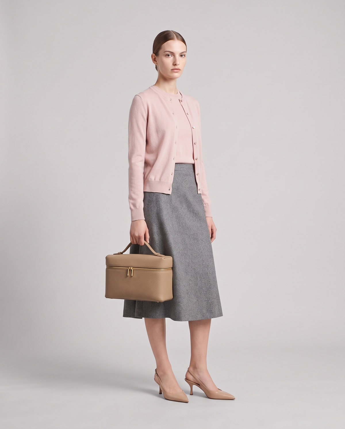 Model holding the Orvieto vanity case in Stone – full-length view