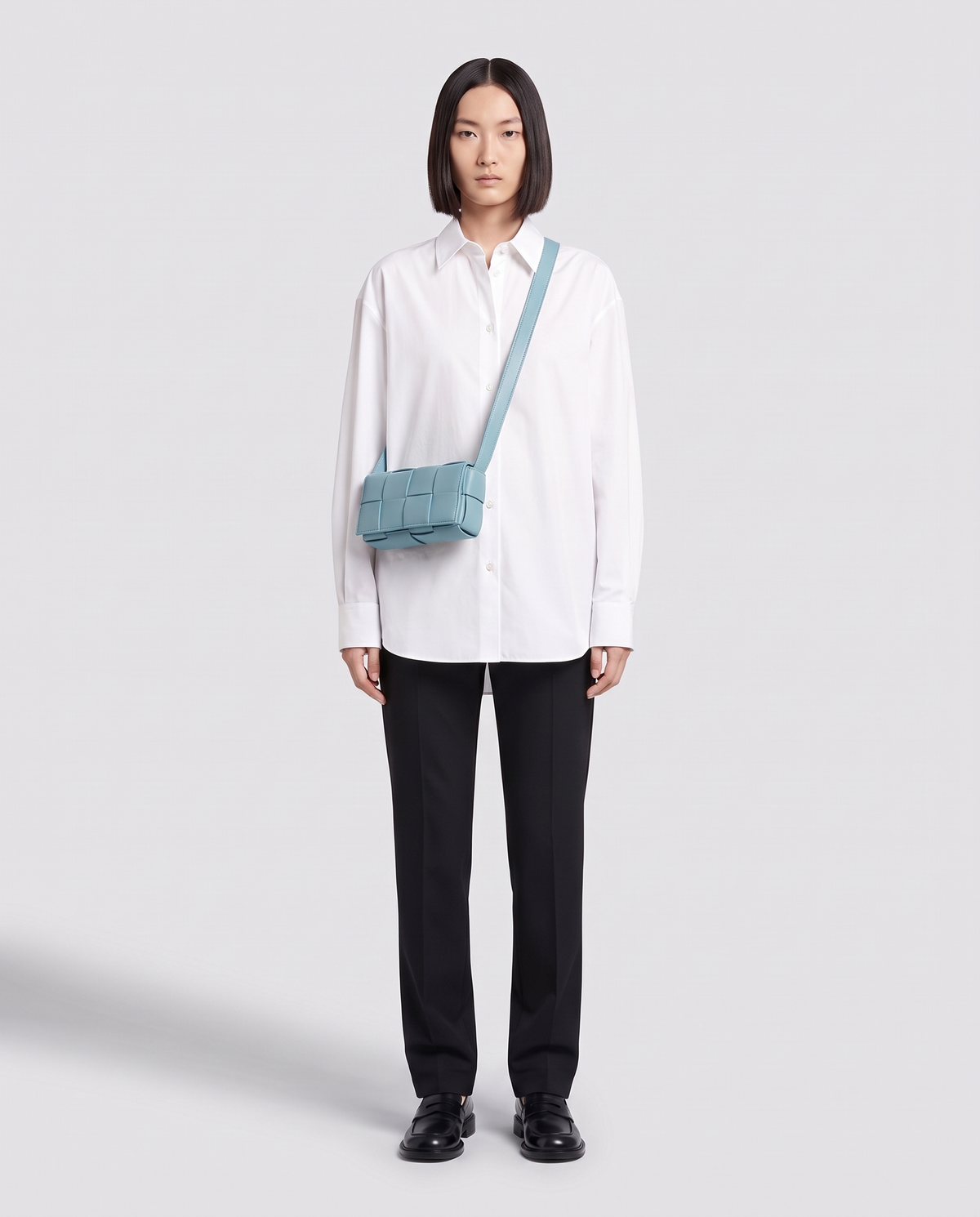 Cassette padded woven leather belt bag in Blue – model wearing it crossbody, full length