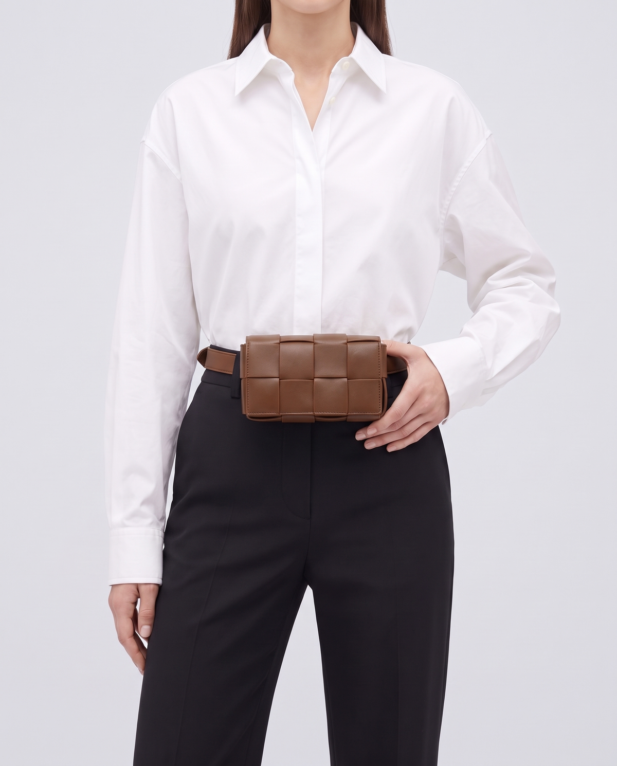 Cassette padded woven leather belt bag in Brown – model wearing it at the waist