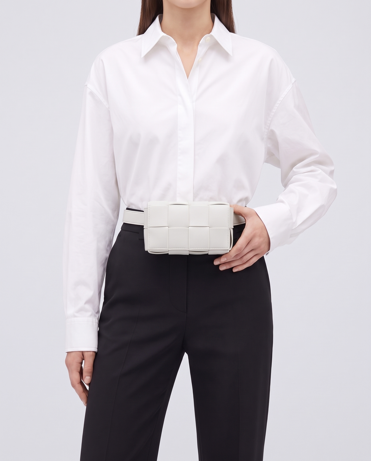 Cassette padded woven leather belt bag in Ivory – model wearing it at the waist