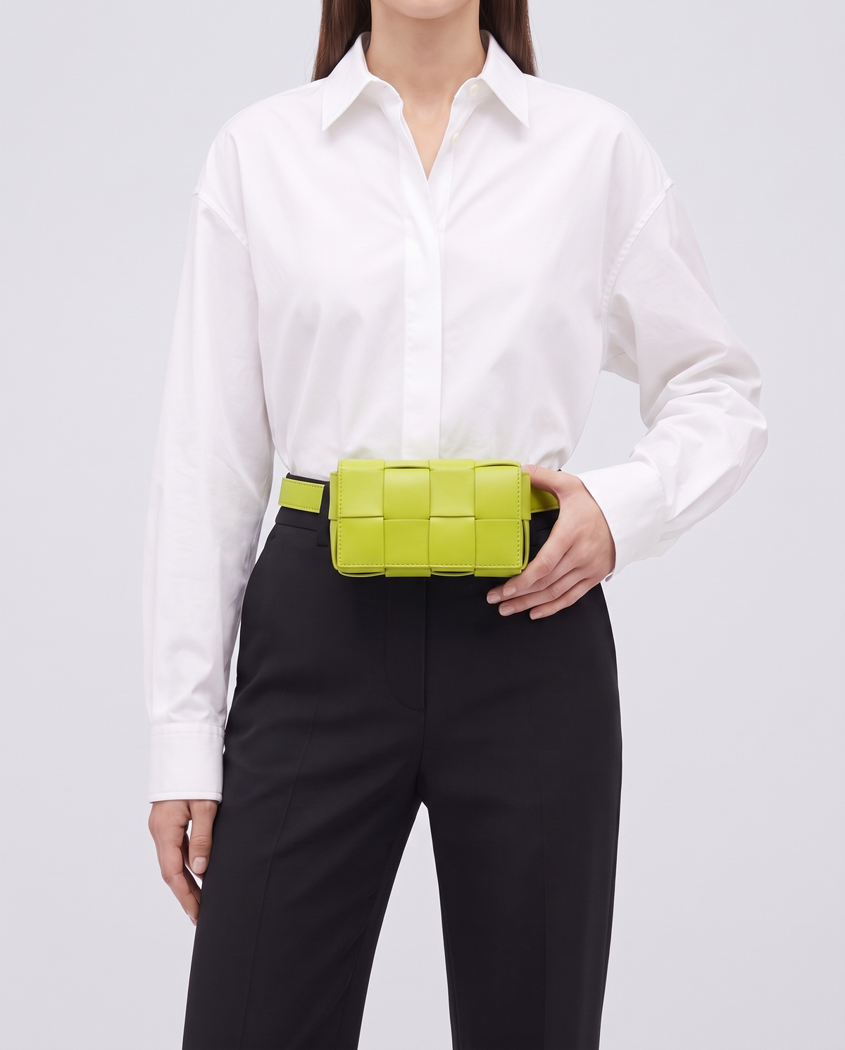 Cassette padded woven leather belt bag in Lime – model wearing it at the waist