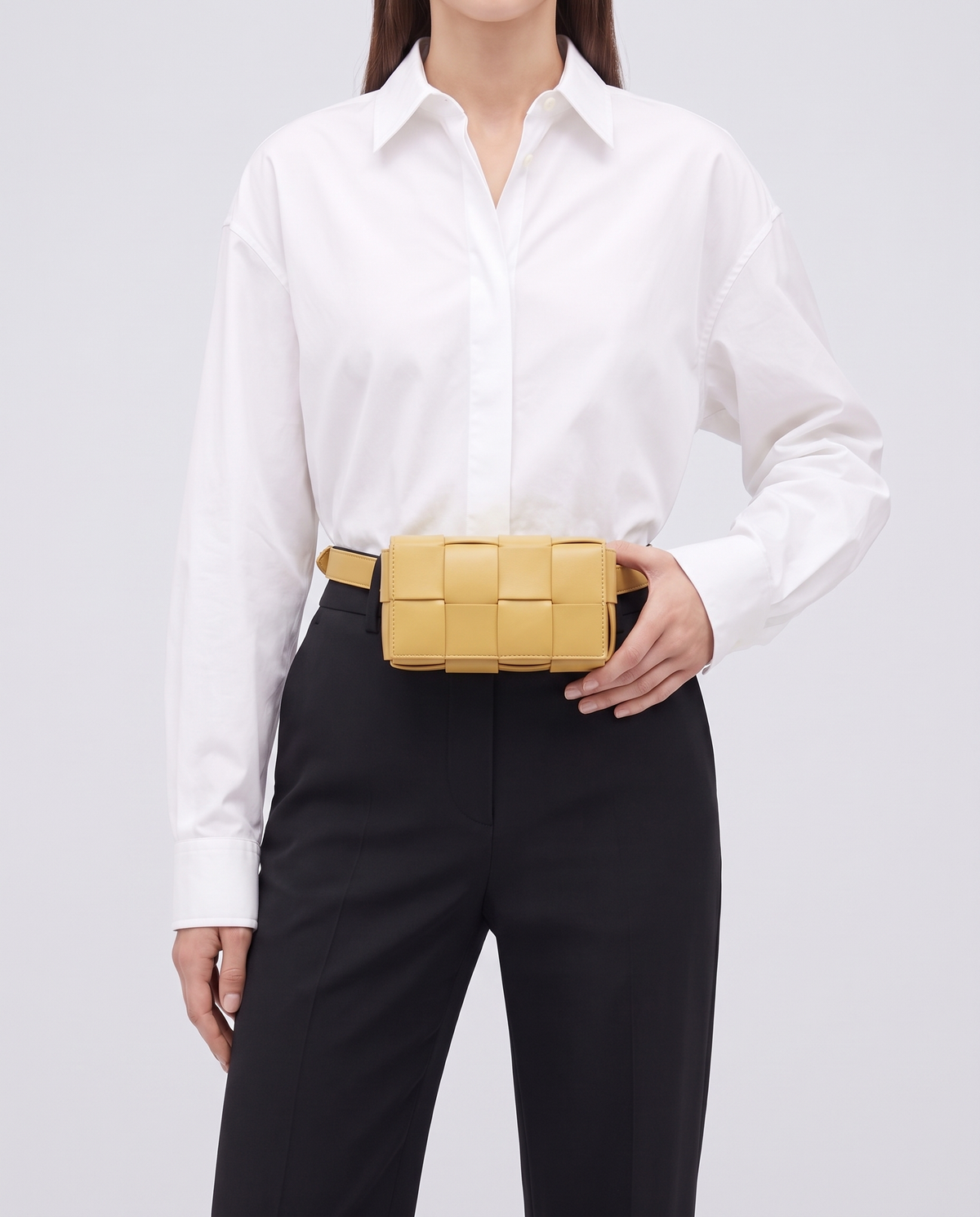Cassette padded woven leather belt bag in Yellow – model wearing it at the waist