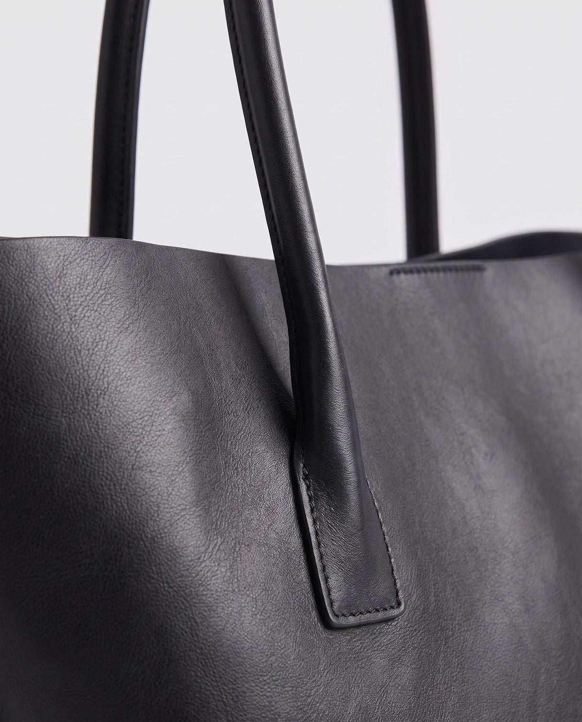 Piano leather tote in Black – close-up of the leather and stitching