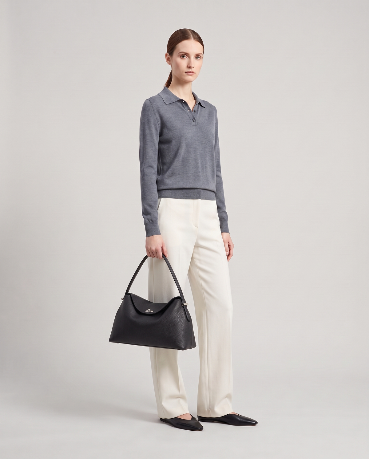 Model holding the Porto top-handle bag in black, full length