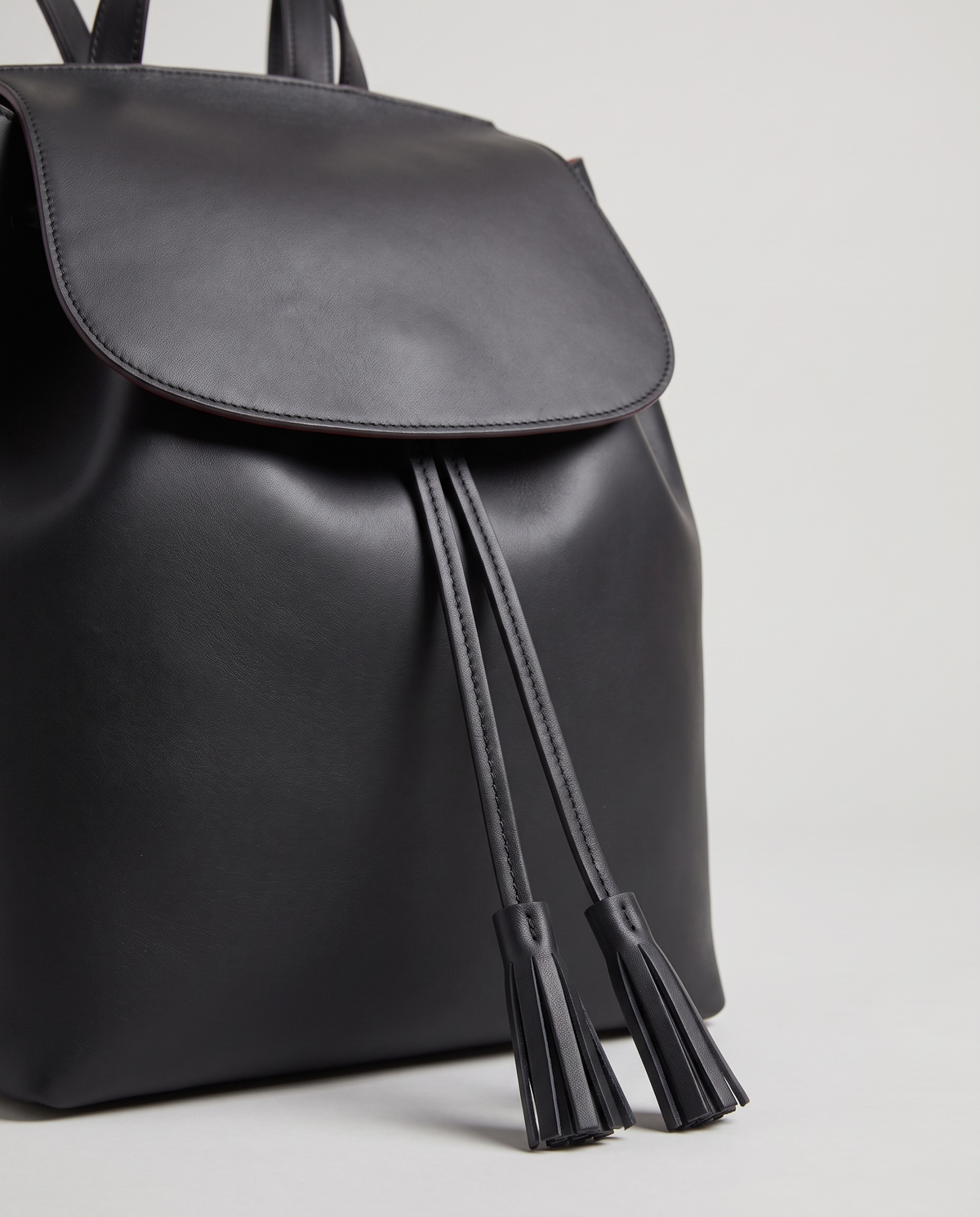 Roam Large leather backpack in Black – close-up of the drawstring tassels and flap