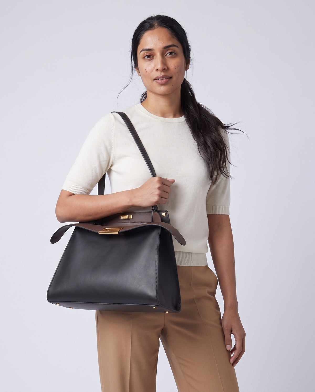 Model wearing the Siracusa leather bag in Black on the shoulder