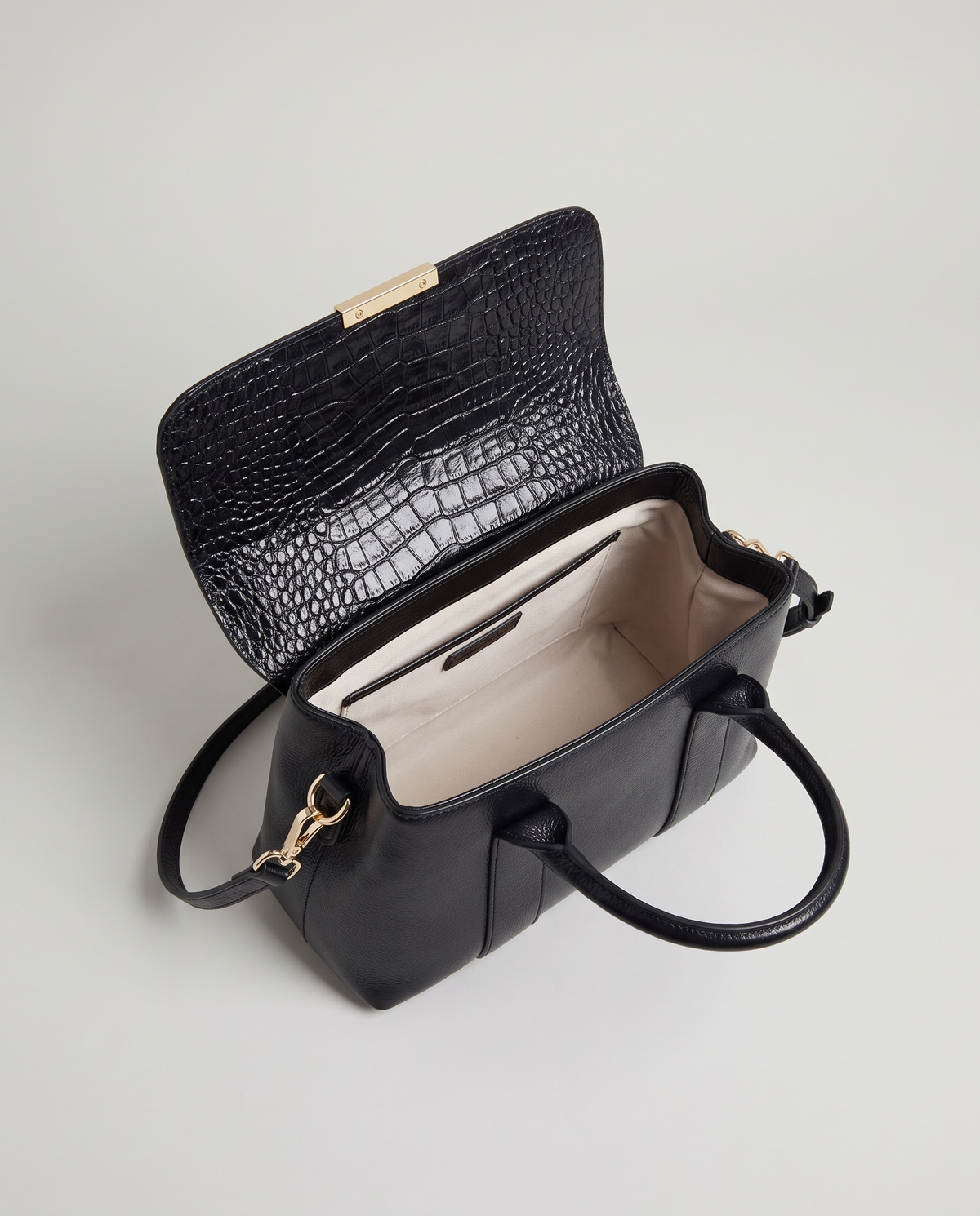 Sloane croc-embossed leather handbag in Black – flap open, showing the lined interior