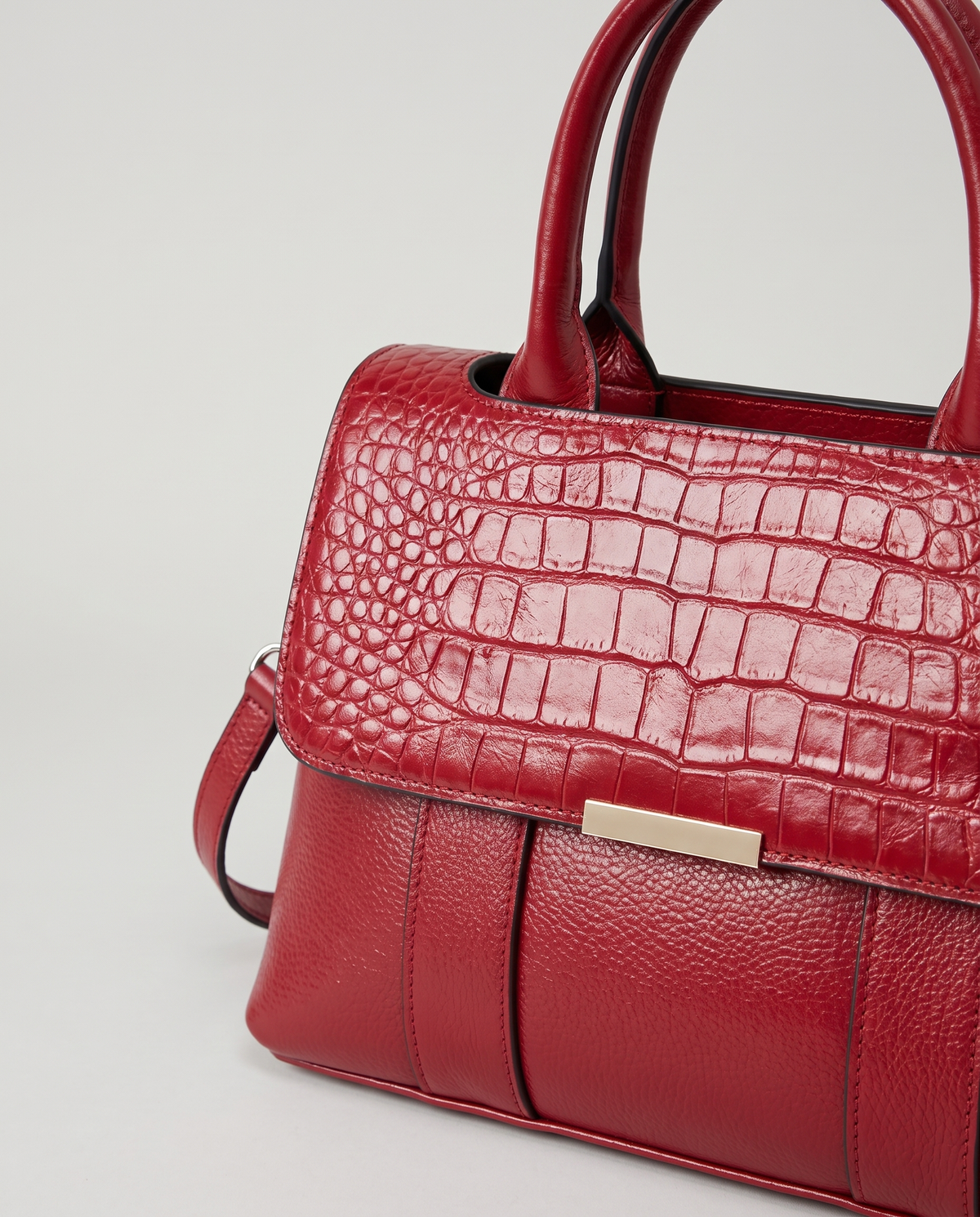 Sloane croc-embossed leather handbag in Red – close-up of the croc flap and gold bar