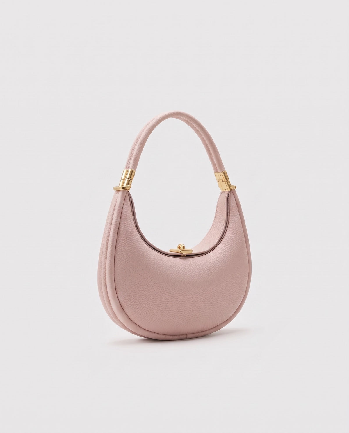 Todi pebbled leather crescent bag in Blush – three-quarter view