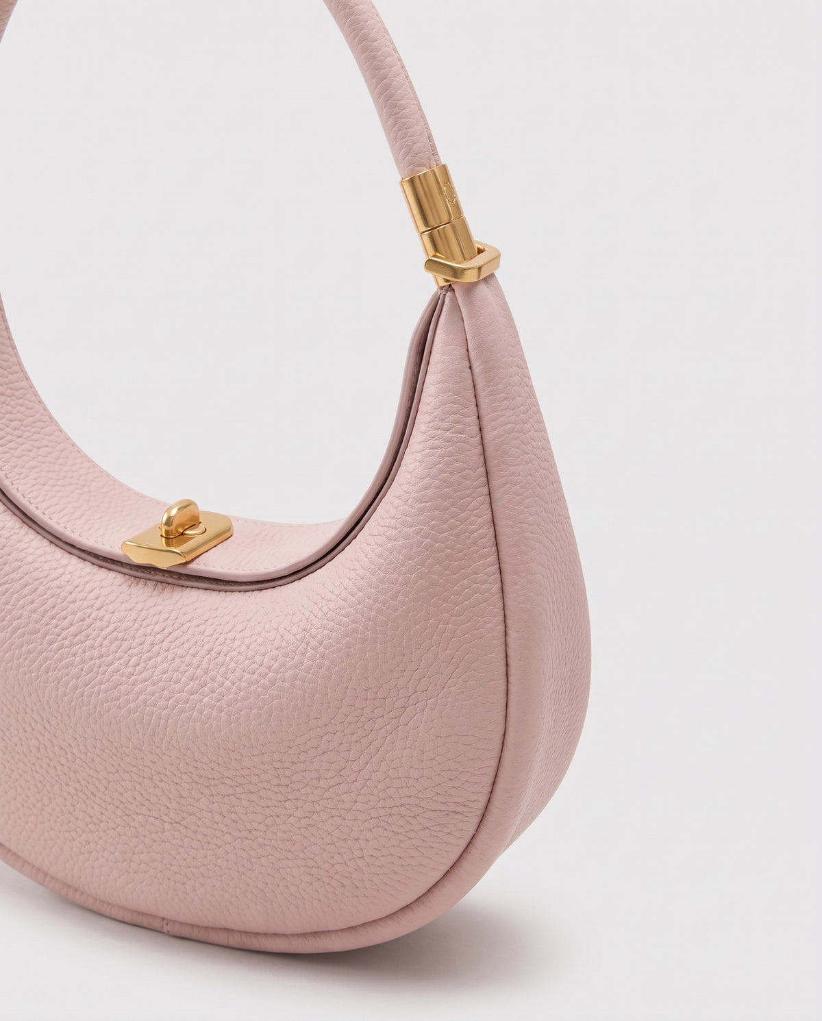 Gold clasp and handle collar detail on the Todi crescent bag in Blush
