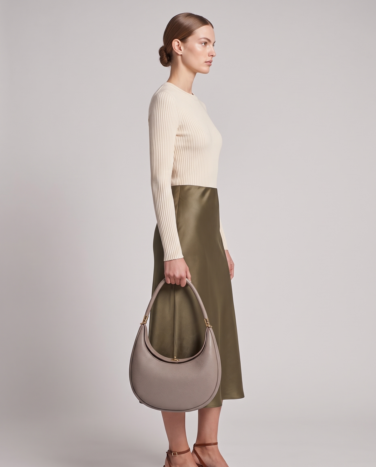 Model carrying the Todi crescent bag in Taupe