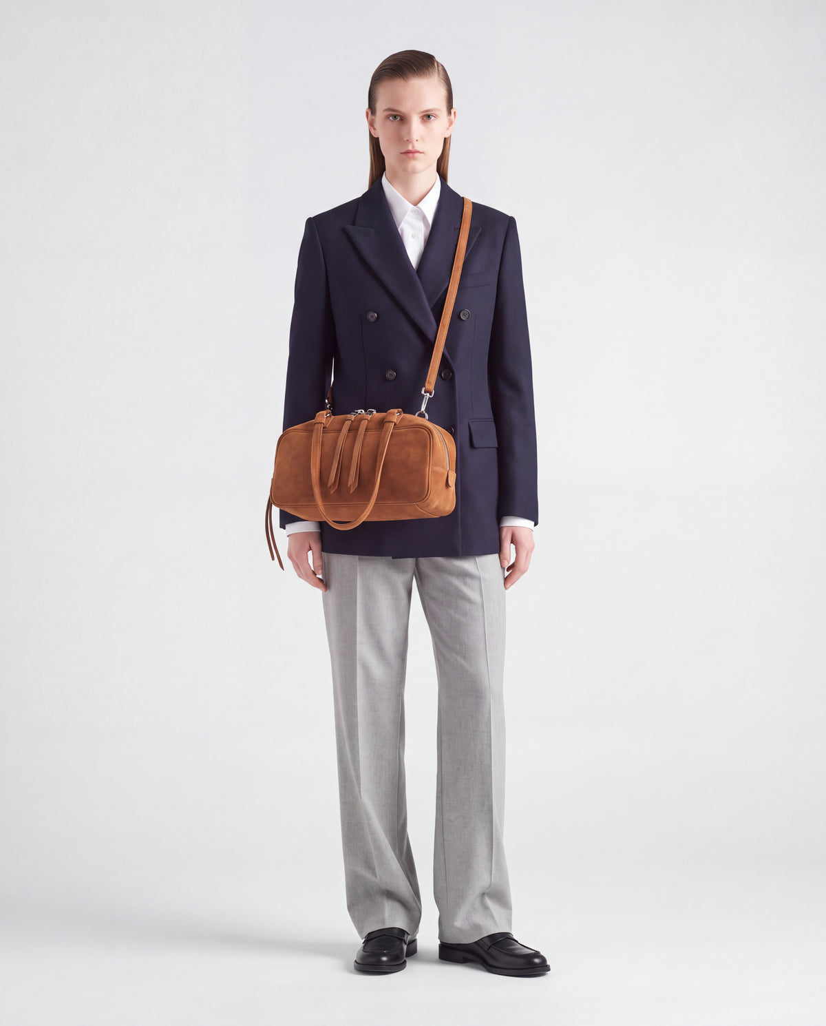 Model wearing the Valentina Linea suede bag in Brown crossbody on its long strap