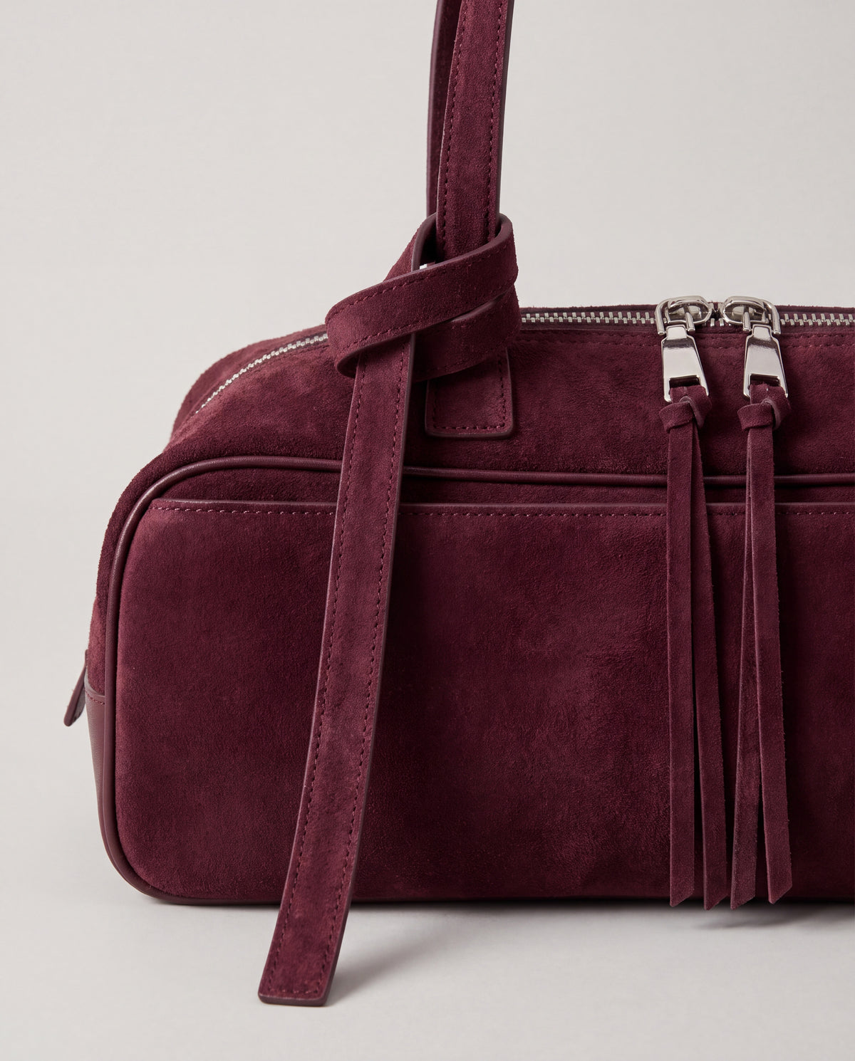 Detail of the knotted strap, double silver zips and suede pulls on the Valentina Linea bag in Burgundy