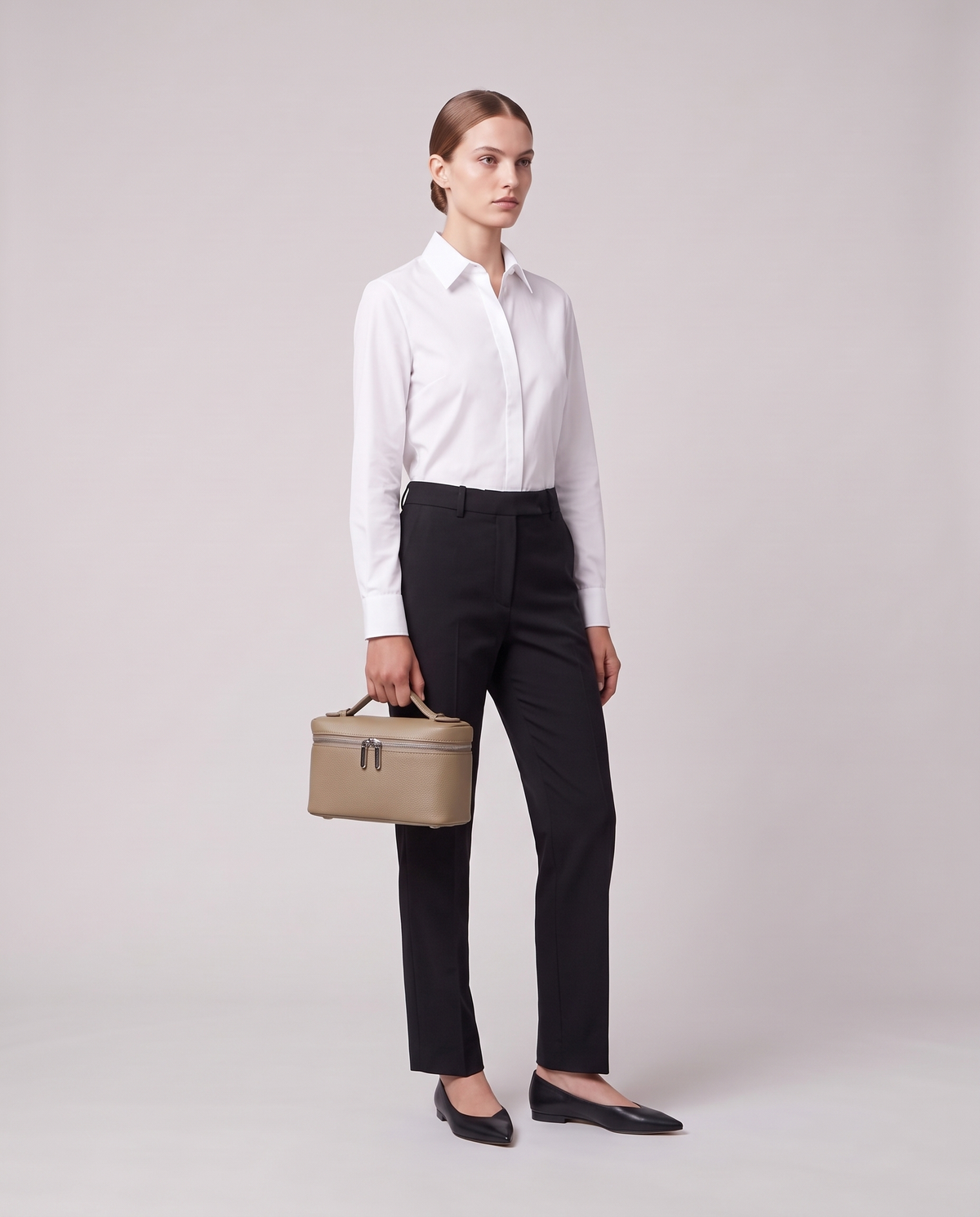 Model carrying the Valentina Orvieto Small top-handle bag in Stone leather