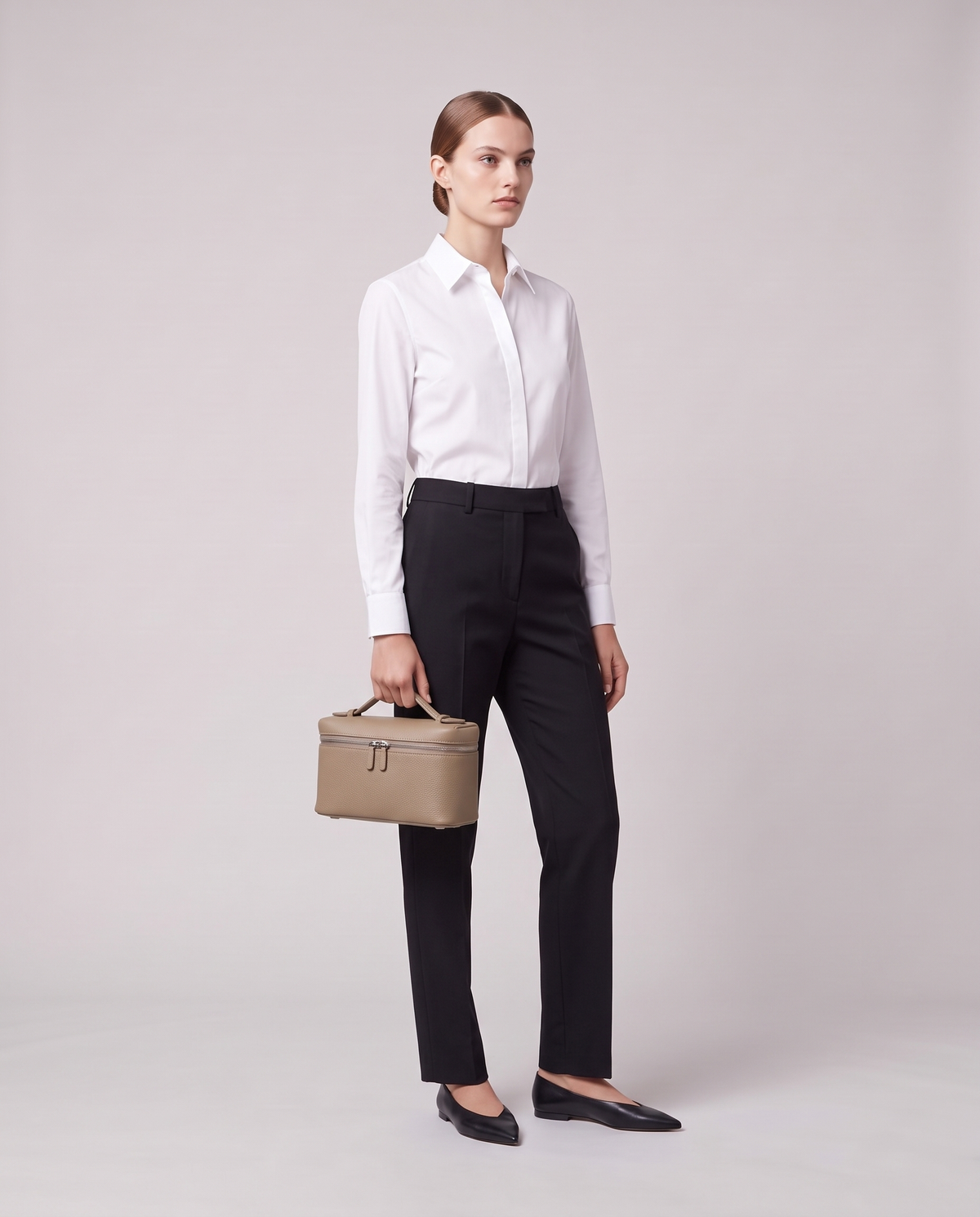 Model holding the Valentina Orvieto Small top-handle bag in Stone leather, full length