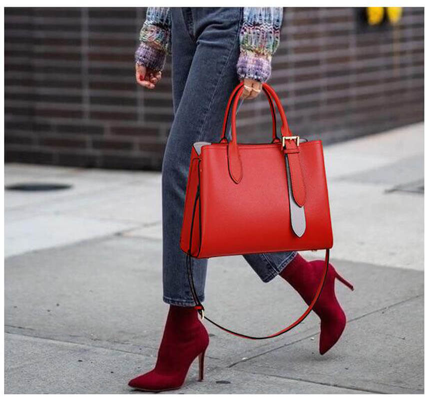 A woman carrying a red leather handbag