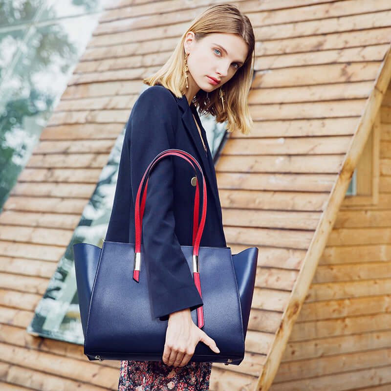 A woman carrying a blue leather tote bag