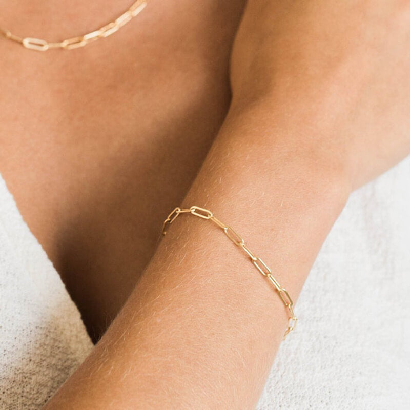 Model wearing gold paperclip bracelet