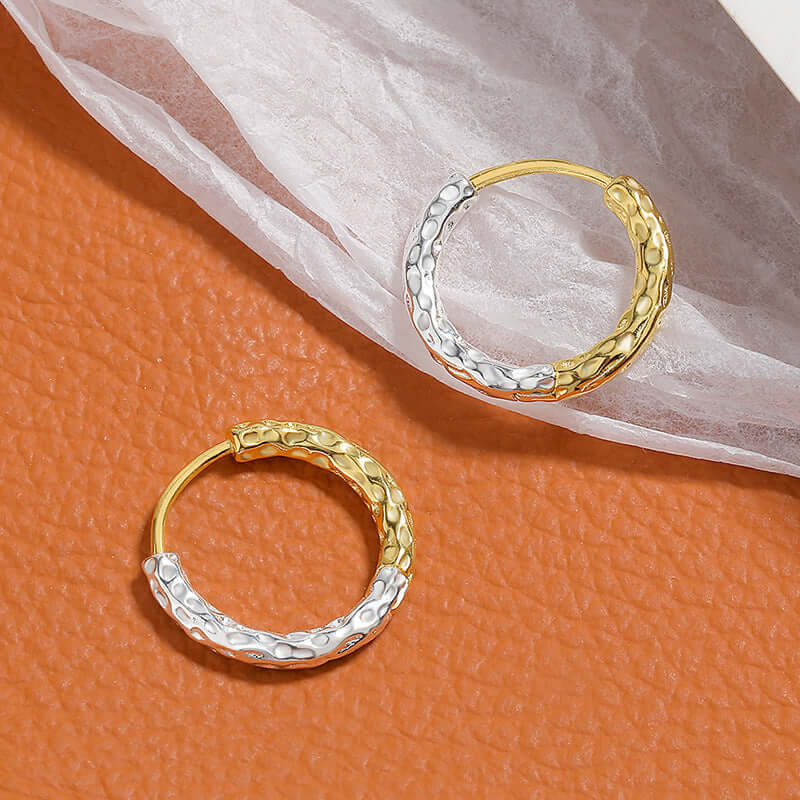 A pair of gold and silver hoop earrings