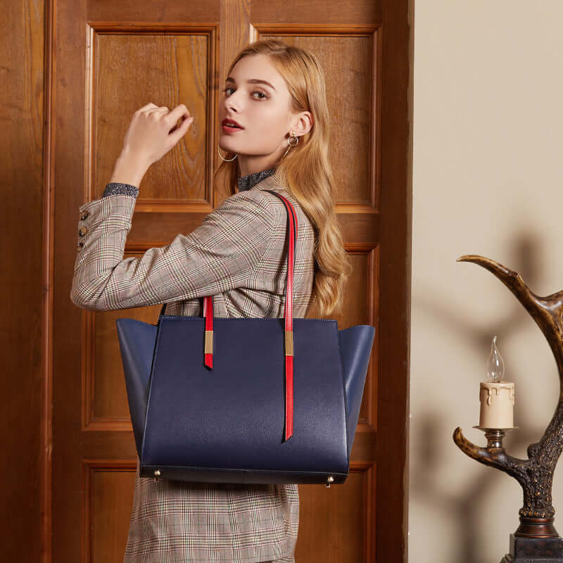 A woman carrying a blue leather tote bag