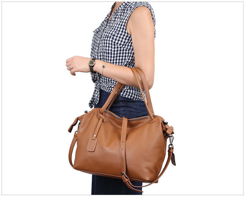 A woman carrying a brown leather tote bag