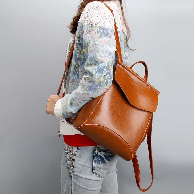 A woman wearing a brown leather backpack