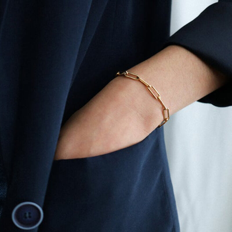 Model wearing gold paperclip bracelet