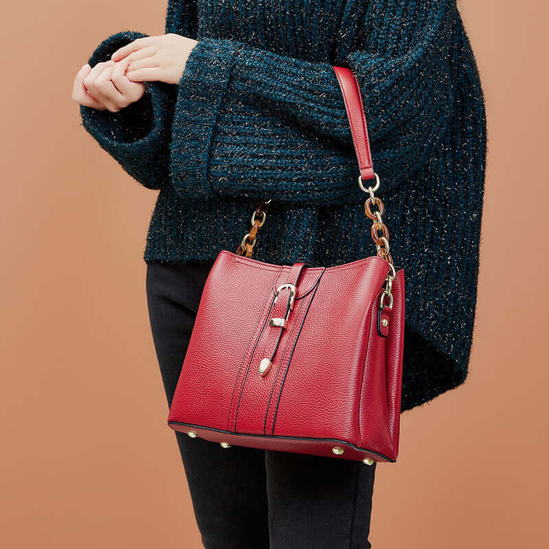 A woman carrying a red bucket bag