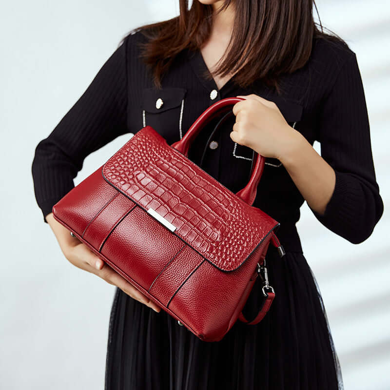 A woman holding a red leather handbag