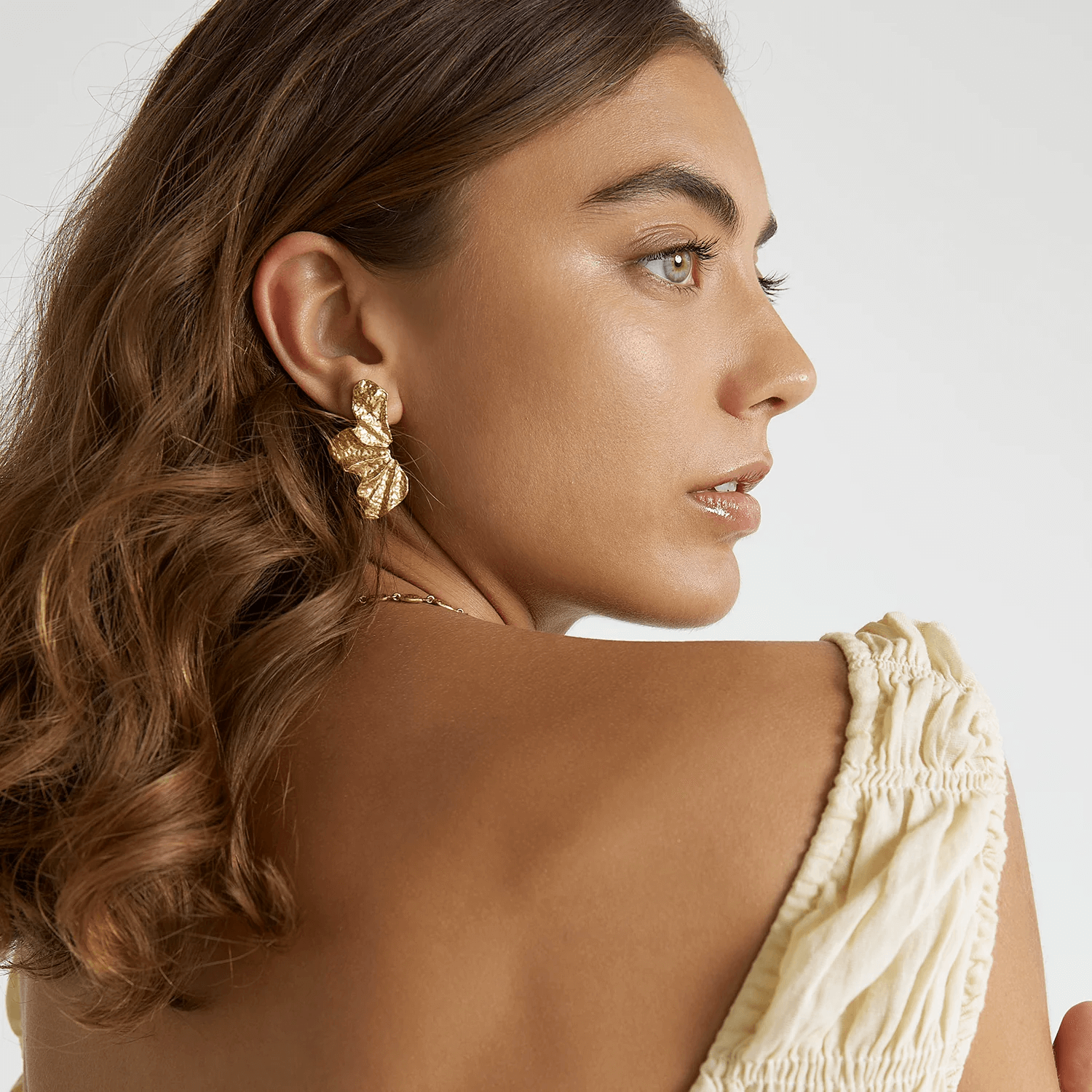 a woman showing her gold earring