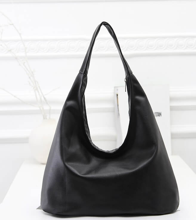 A simple black shoulder bag made of genuine leather, displayed against a white background.
