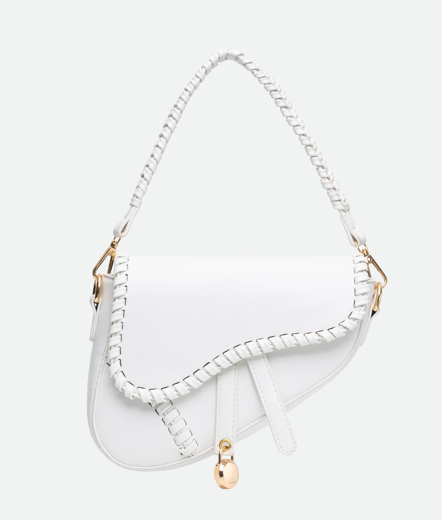 A white saddle bag with gold accents and a braided handle, crafted from vegan leather, featuring intricate stitching.