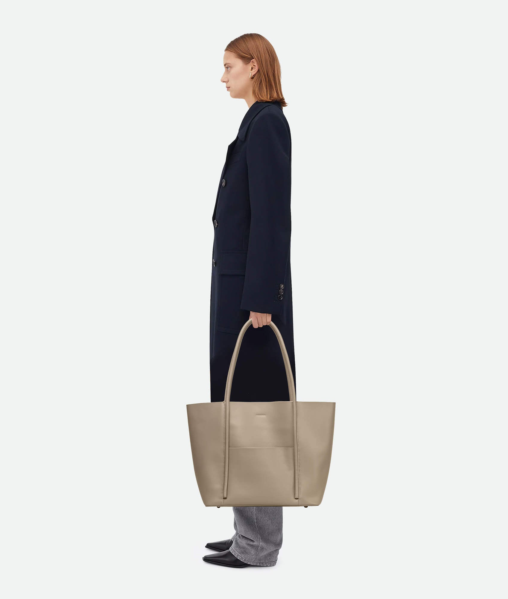 Model carrying a Beige leather tote bag