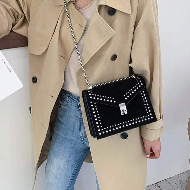 A girl carrying a black studded vegan leather bag