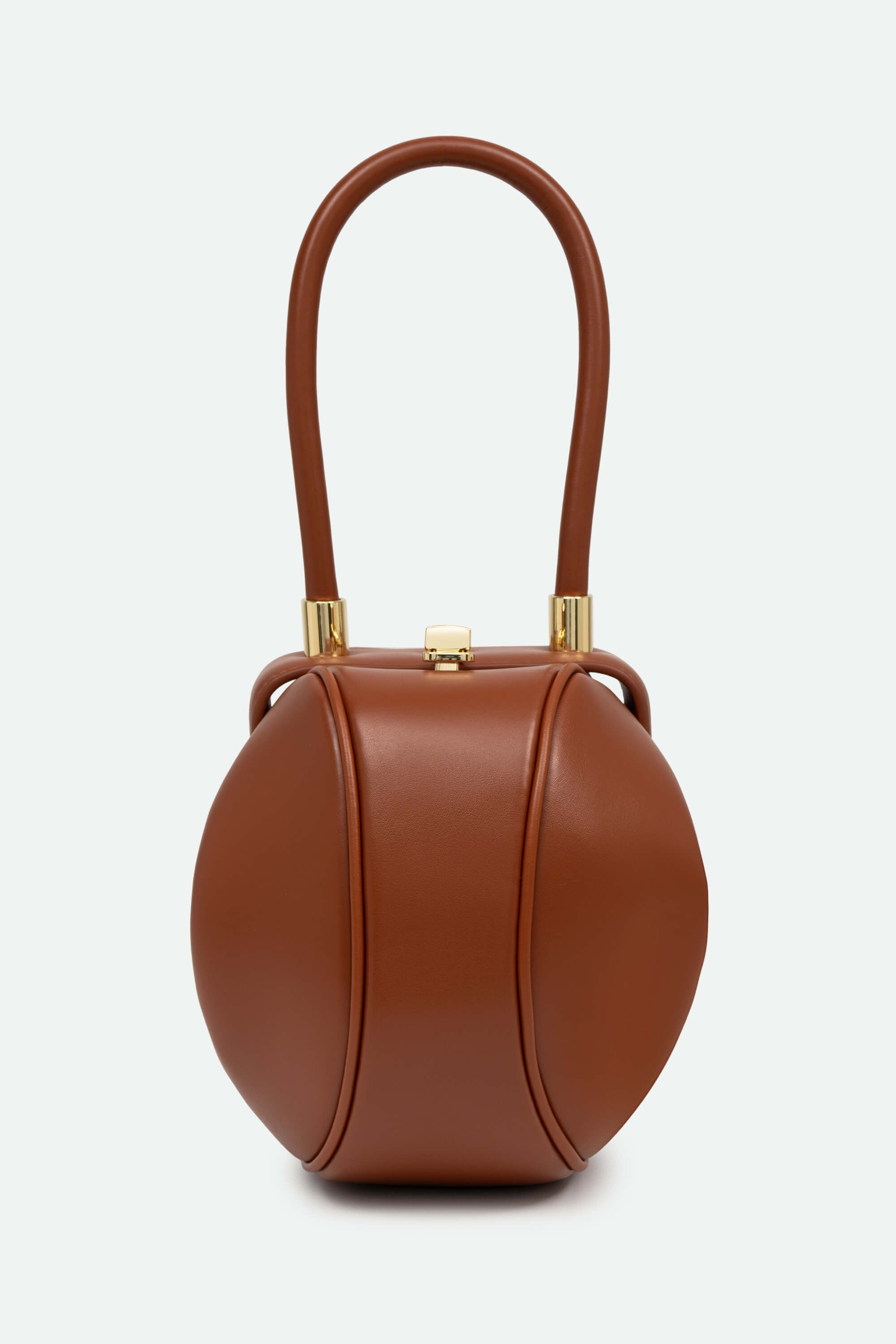 Brown leather handbag with a handle on a light gray background