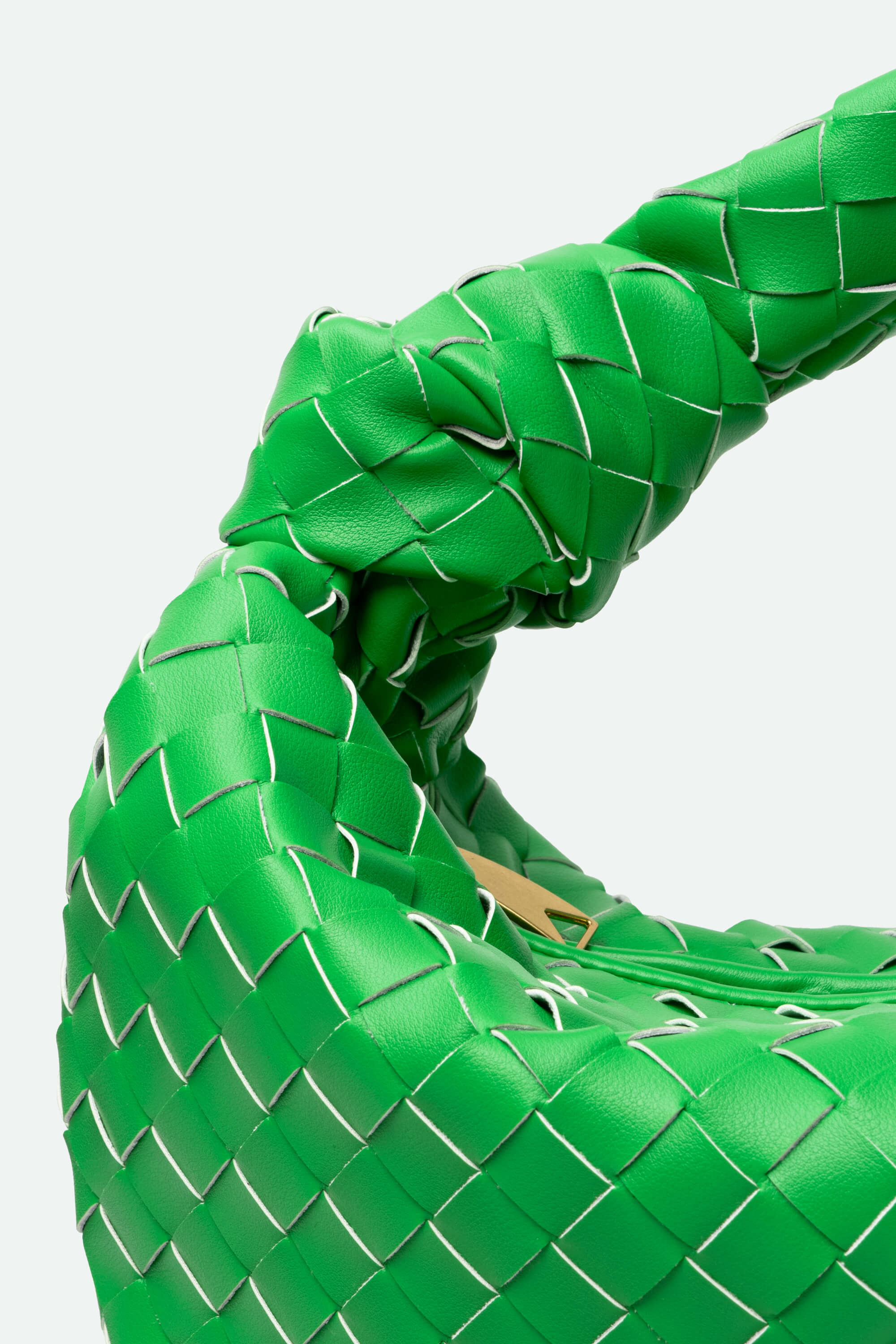 Close-up of a green woven shoe on a light gray background