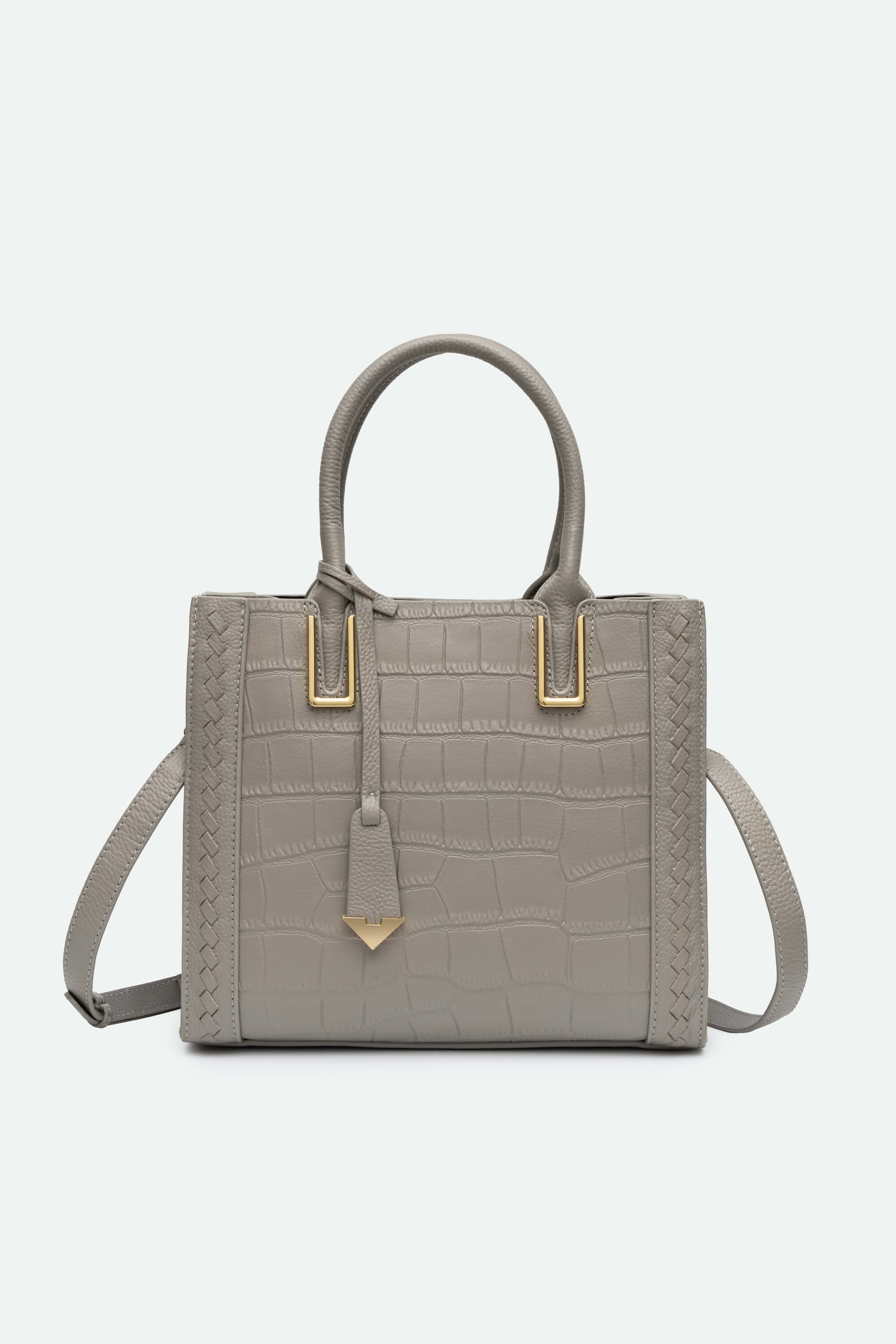 Gray handbag with gold accents on a light gray background