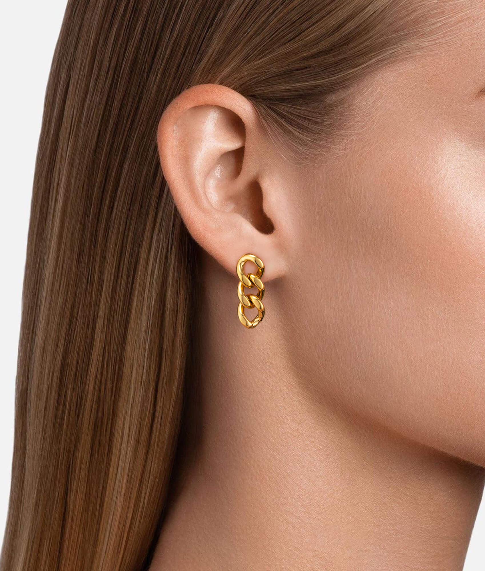 Model wearing link chain earrings gold