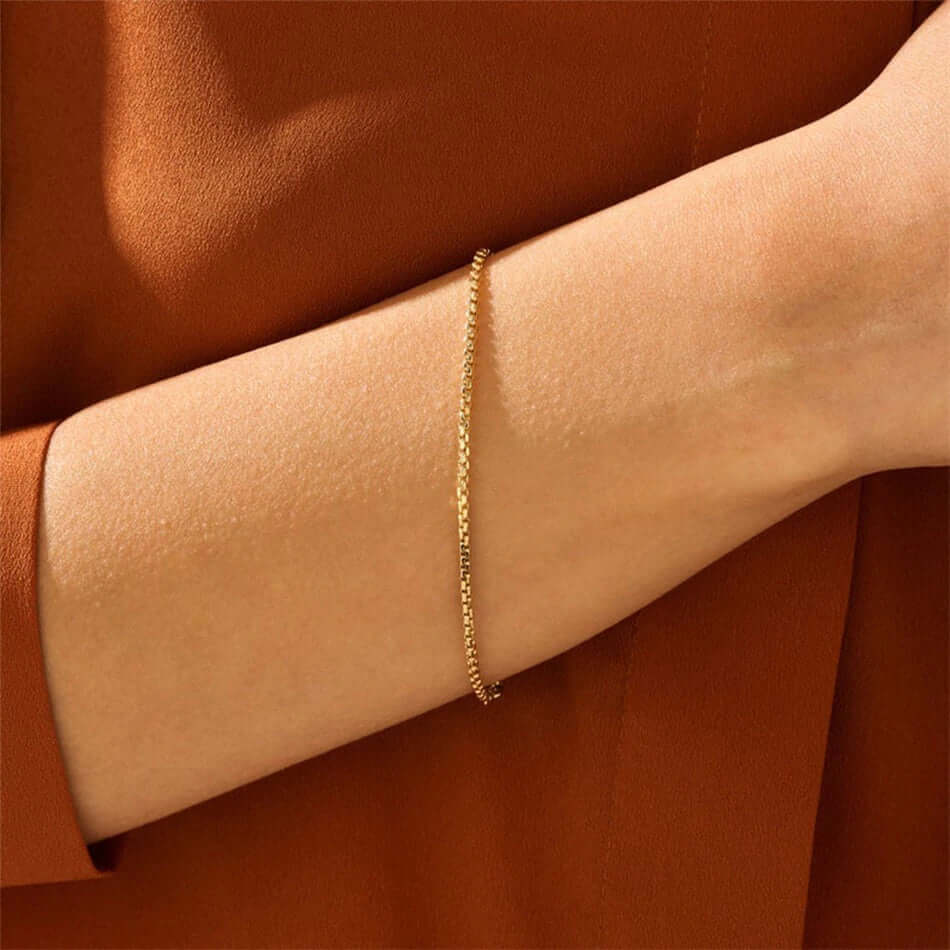 A model wearing a gold cube link bracelet