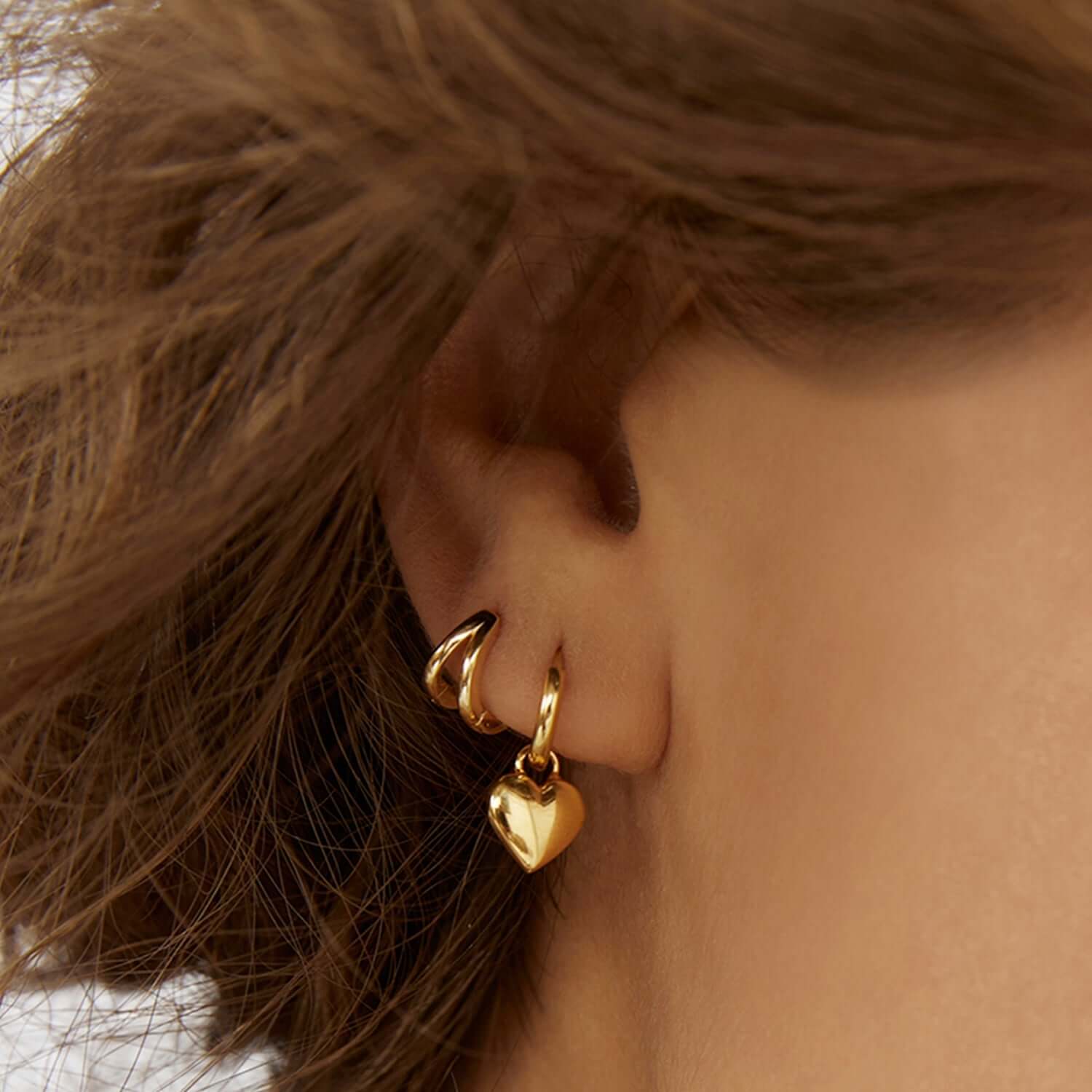 A woman showing her gold stack earrings